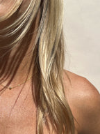 Model with blonde hair wearing the yellow gold-filled Petite Ball Choker necklace, captured in sunny, warm light for a radiant vibe