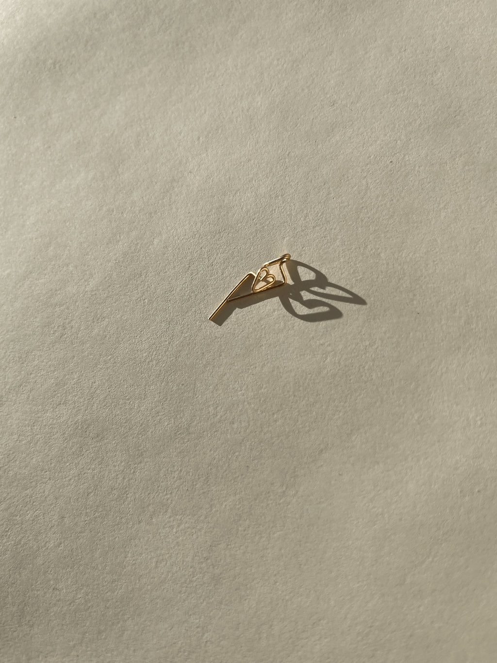 Petite Heart Drop-Back Earrings displayed on a neutral background, featuring a minimalist heart front and the drop-back post in gold-filled