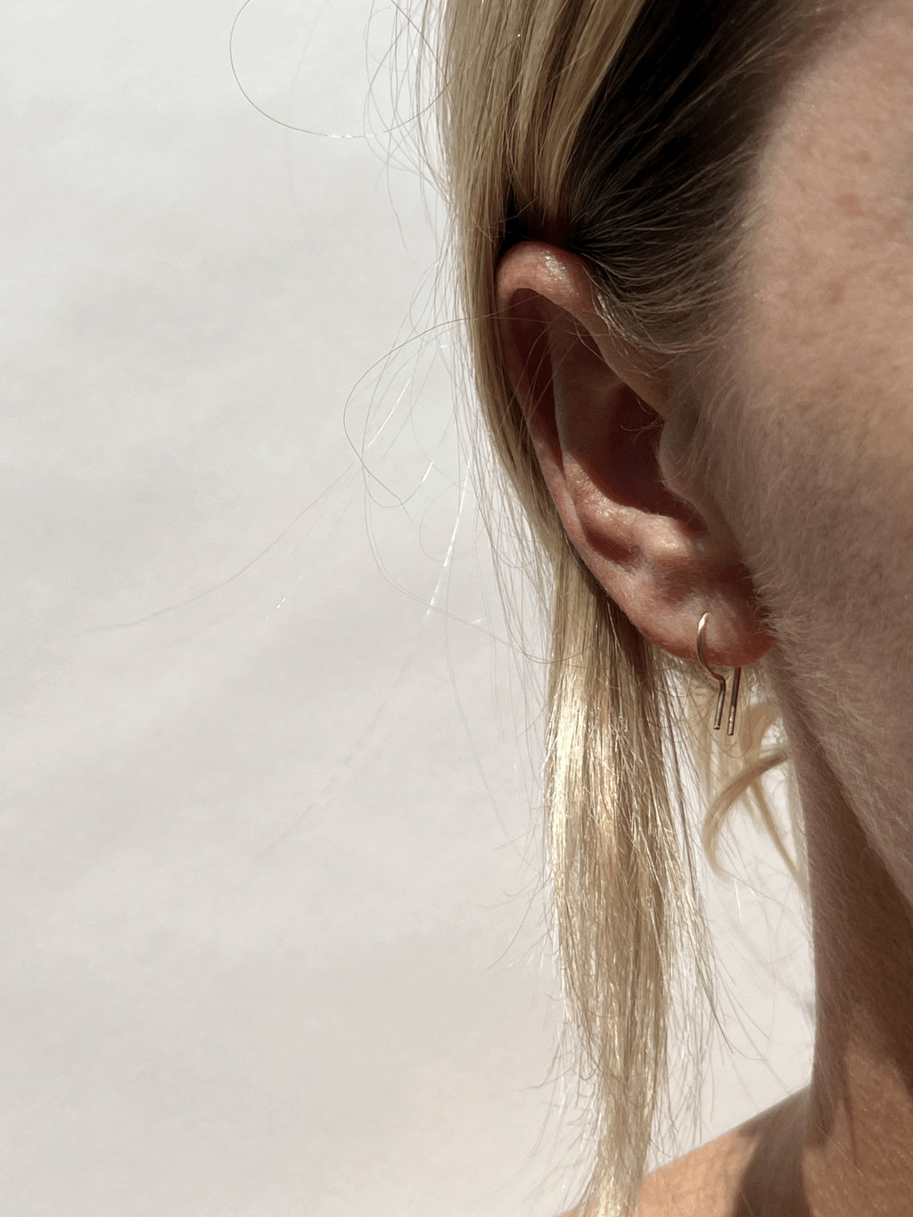Petite R Staple Earring in yellow gold-filled in models first ear piercing 