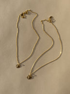 Full product shot of both Sand Dollar Necklaces, 10mm and 12mm charms, displayed on a neutral background