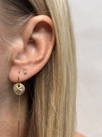 Close-up view of the 10mm yellow gold-filled sand dollar threader earring paired with a small clear crystal stud earring