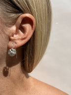 Model wearing a large sterling silver sand dollar threader earring in her first ear piercing, with the chain threaded through her second ear piercing