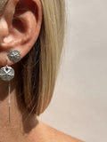 Model wearing a 12mm sterling silver sand dollar threader earring in her first ear piercing and a large sterling silver sand dollar stud earring in her second piercing