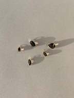 Collection of Thalken 14k solid gold single drop earring charms in natural smoky quartz, featuring pear, marquise, and oval shapes, displayed unattached to hoops for customizable styling