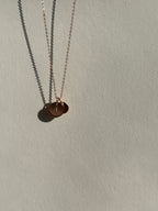 Rose gold-filled 9mm disc charm with an uppercase “T” in front, with a 7mm “H” charm layered behind