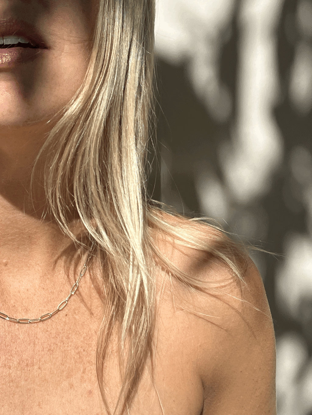 Model wearing the sterling silver medium link paperclip necklace, mouth slightly open, hair styled naturally
