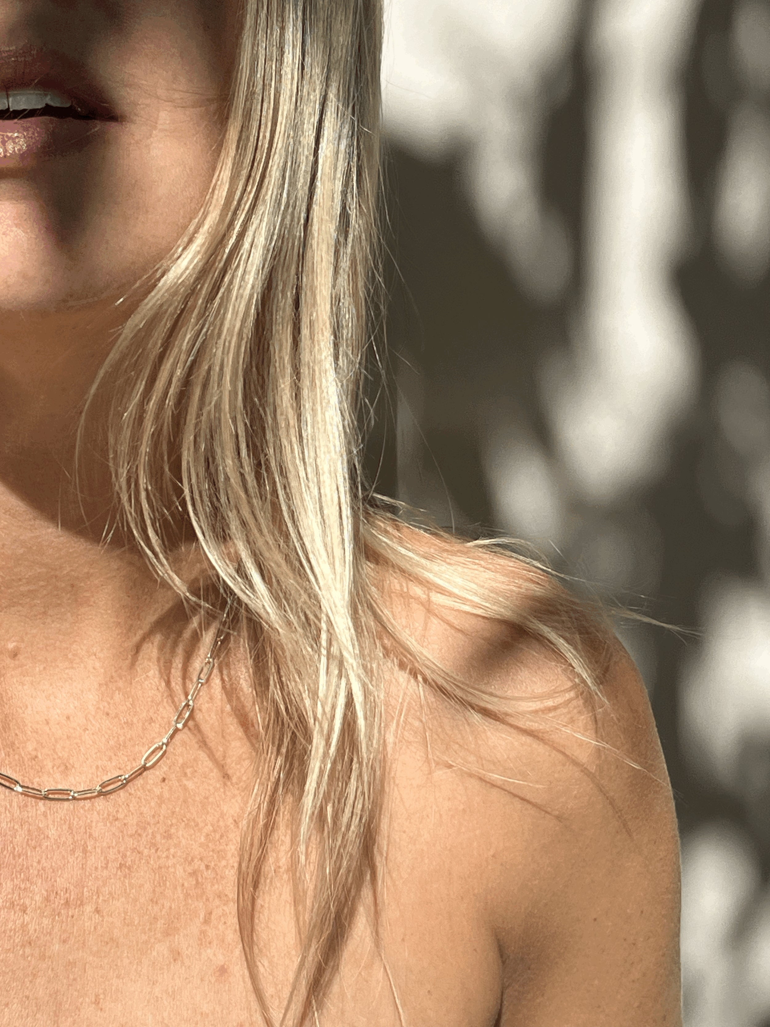 Model wearing the sterling silver medium link paperclip necklace, mouth slightly open, hair styled naturally