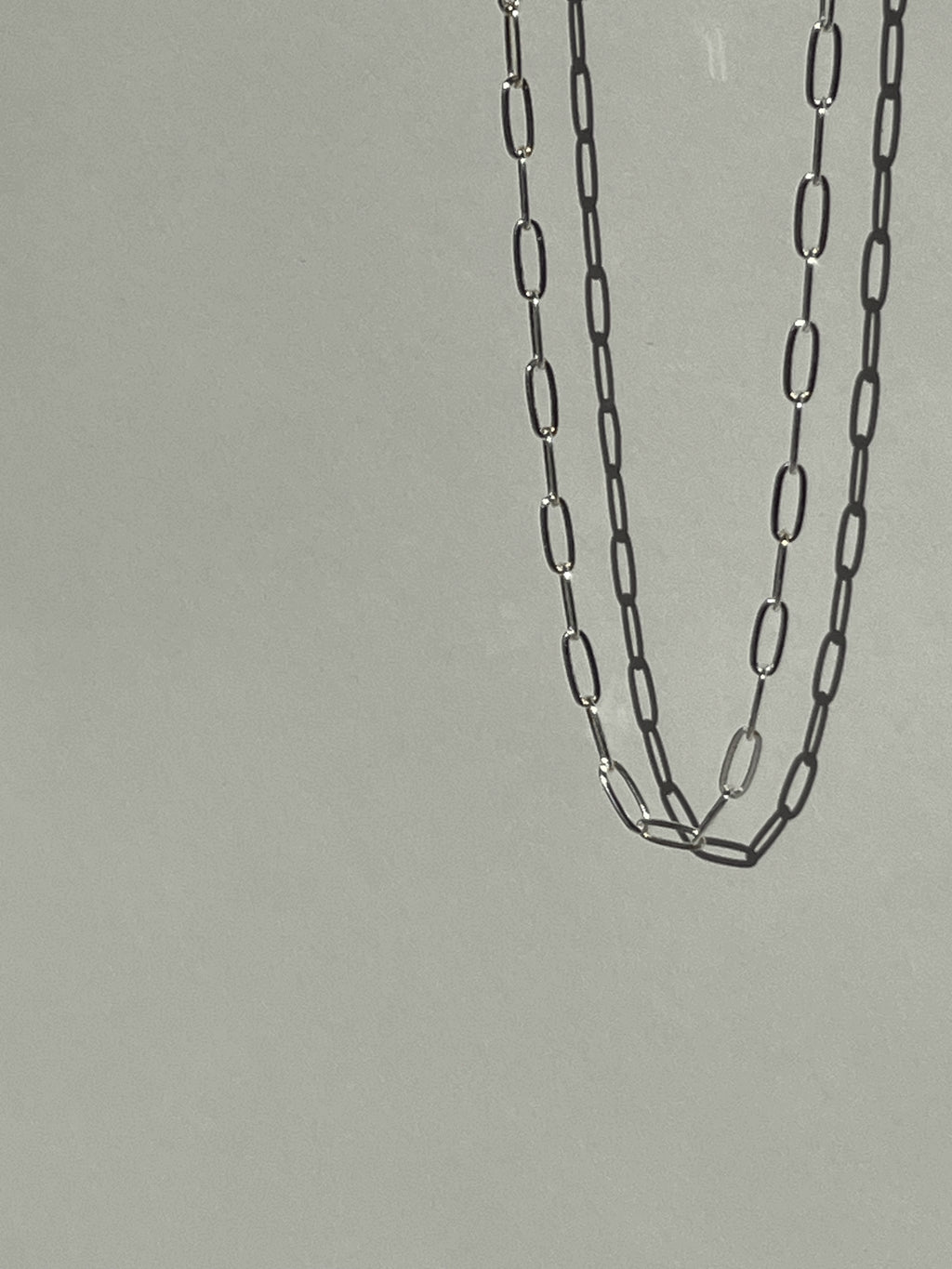 Sterling silver medium link paperclip necklace suspended in air, highlighting the elongated links