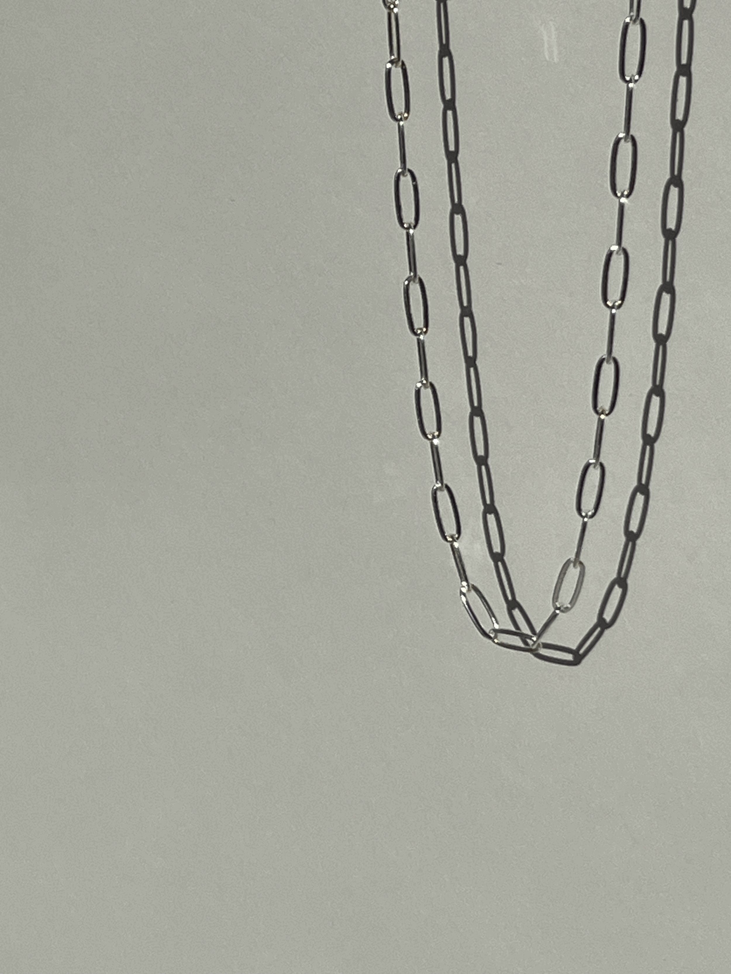 Sterling silver medium link paperclip necklace suspended in air, highlighting the elongated links