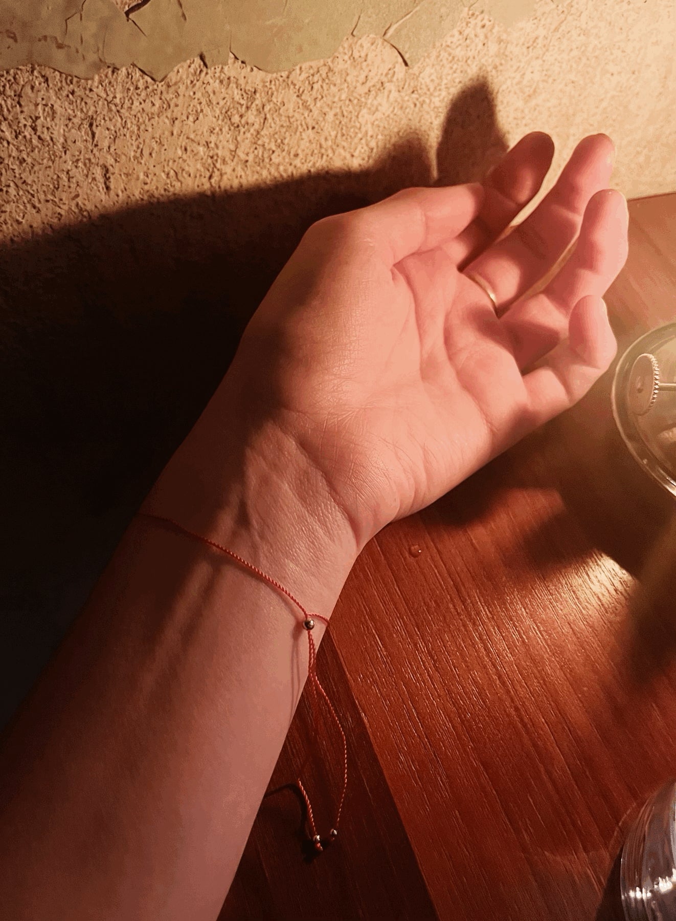 Model’s wrist turned to show the inside view of the Thalken® I AM bracelet, highlighting the adjustable sliding bead component and thin red cord detail