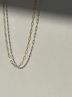 Yellow gold-filled small link paperclip necklace suspended in air with soft shadows