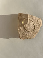 Thalken Perfect Curb Chain Bracelet in yellow gold-filled displayed on a rock in warm light at an angle