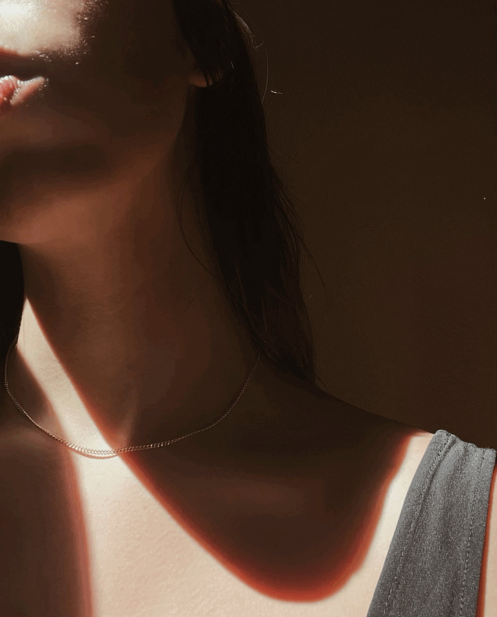 Model wearing the Perfect Yellow Gold-Filled Curb Chain Necklace, artistic lighting with soft shadows