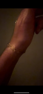 Artistic shot of Thalken’s Small Link Paperclip Bracelet with The Perfect Curb Chain Bracelet, blurred glimmer highlighting its gold-filled shine