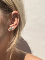 Model wearing a large sterling silver turtle stud in her first ear piercing and a small sterling silver turtle stud in her second ear piercing