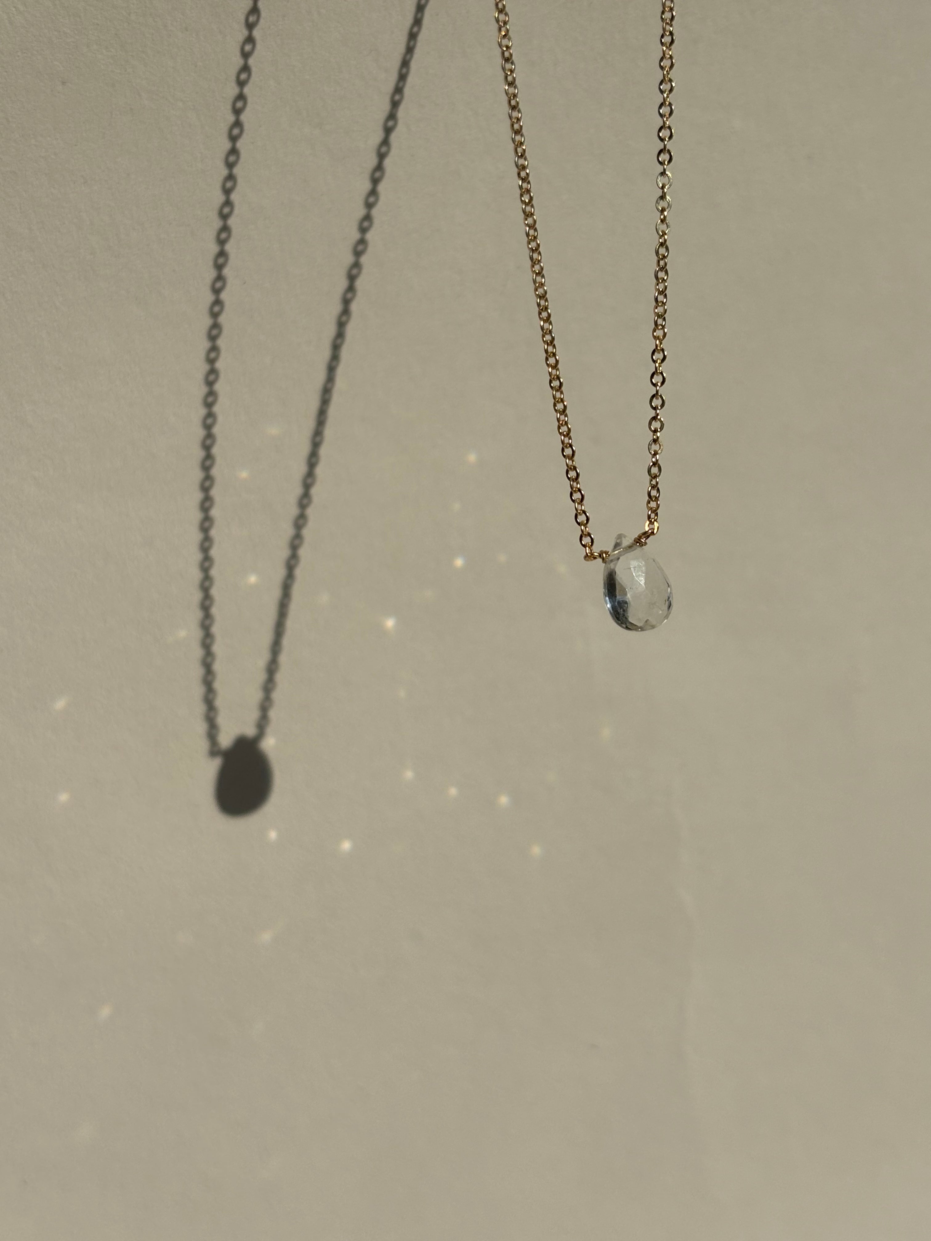 Thalken Natural White Topaz Drop Necklace suspended in air with sparkling light reflections from the stone